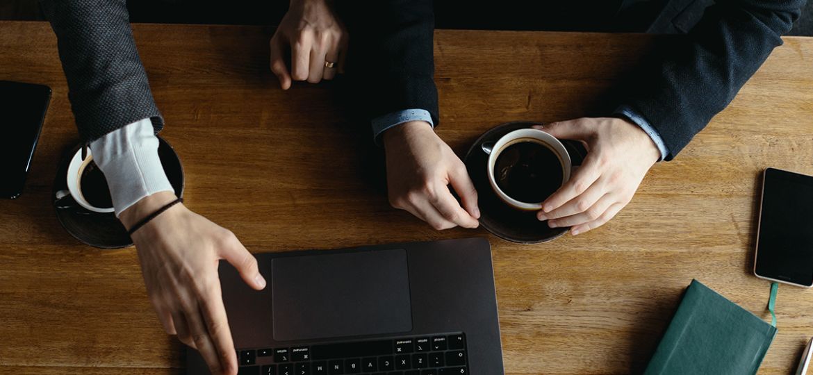 two-businessmen-pointing-laptop-screen-while-discussing