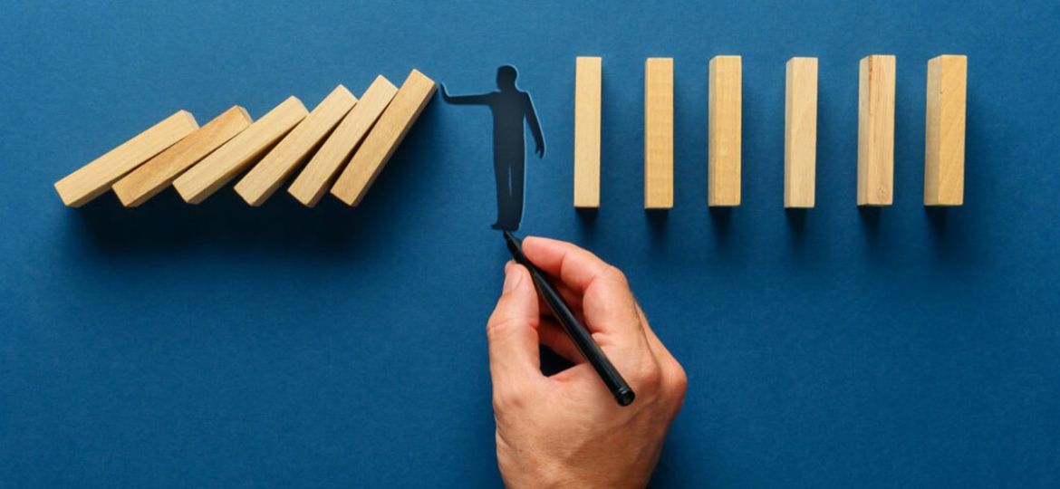 silhouette-man-making-stop-gesture-prevent-wooden-dominos-from-collapsing-2048x683